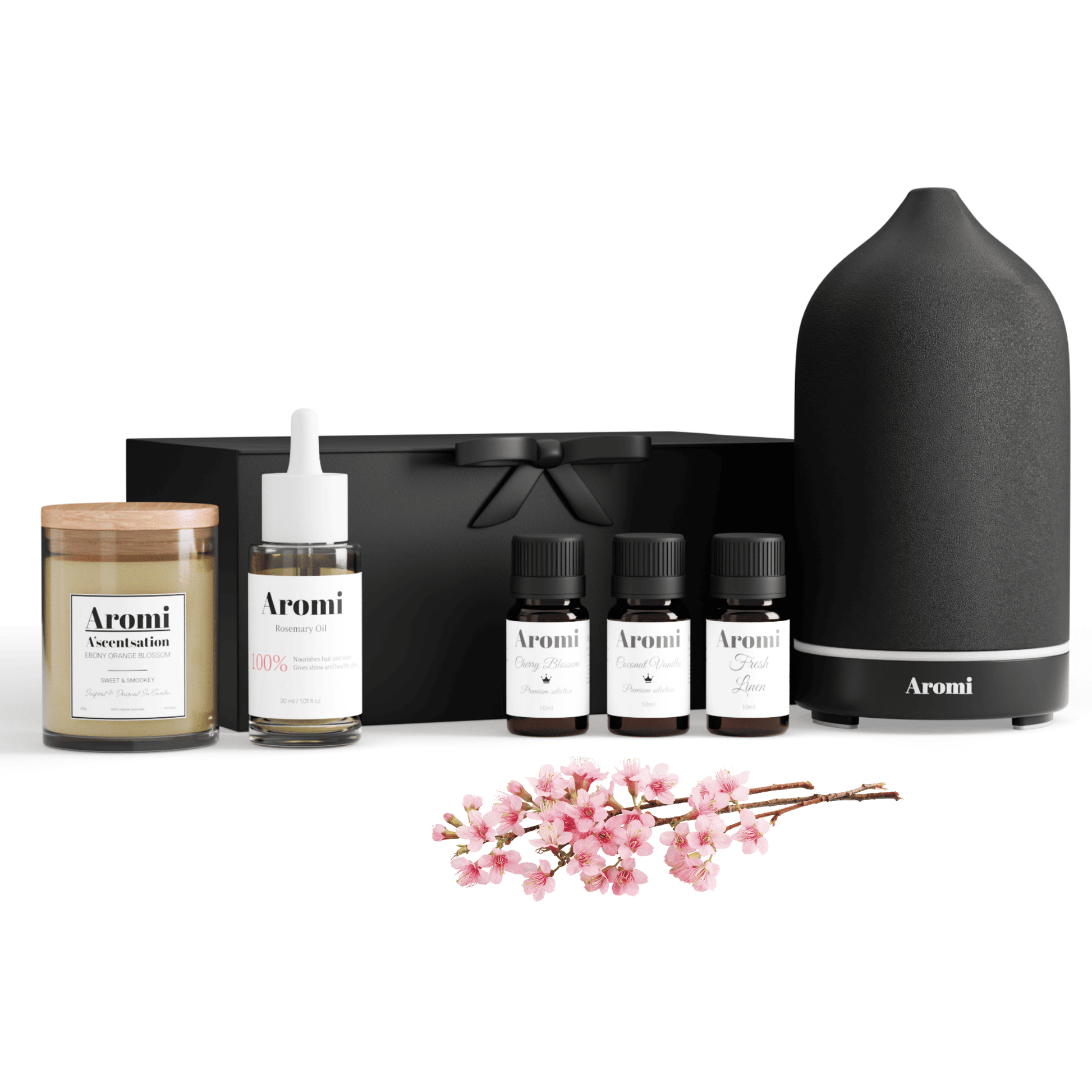 Svart diffuser, 3 eteriska oljor. doftljus och rosmarinolja. Frontvy vit bakgrund